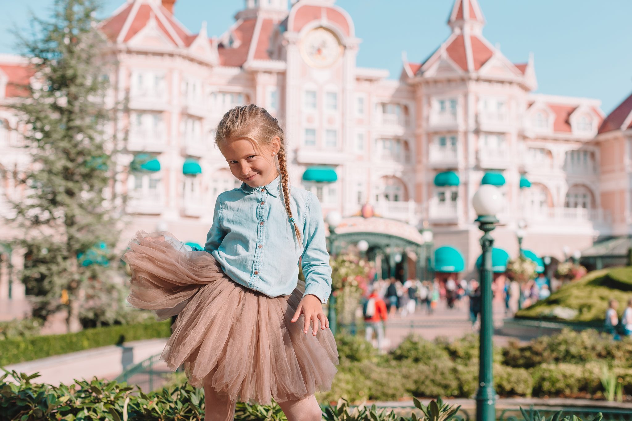 Little adorable girl in Cinderella dress at fairy-tale Disneyland park