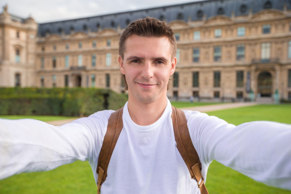 Young man taking a selfie photo outdoors in Paris, France